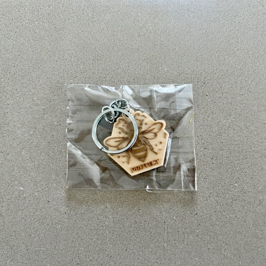 Porte-clés Protect en forme d'abeille dans son sachet transparent.