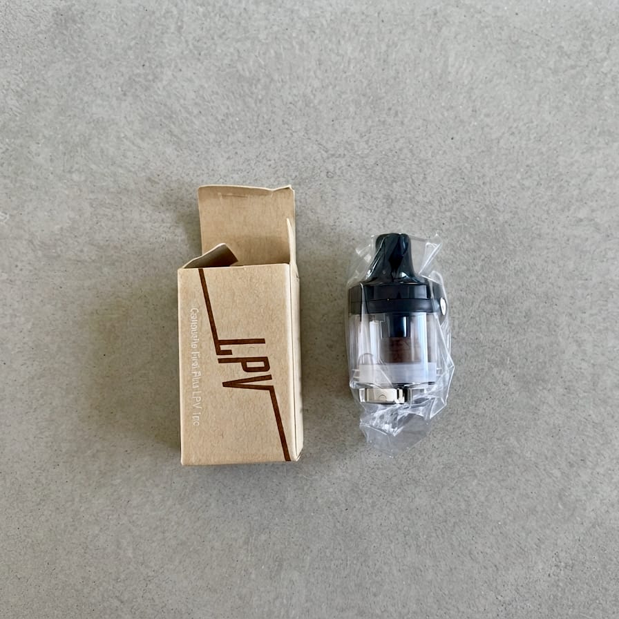 Cartouche First Plus LPV dans son emballage, à côté de sa boîte en carton.