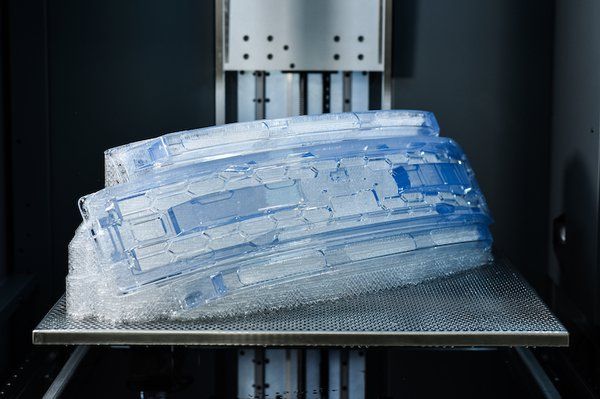 The automotive grill shown here on a Stratasys Neo800 stereolithography system was 3D-printed with clear Somos WaterShed CX 11122. - Stratasys/ Covestro