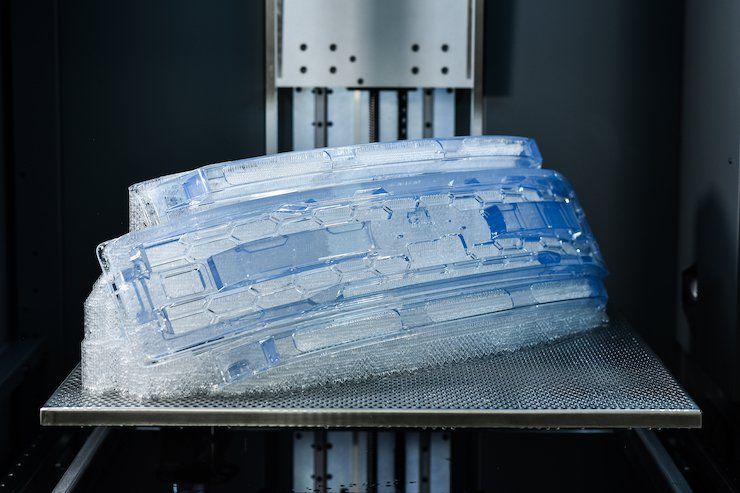 The automotive grill shown here on a Stratasys Neo800 stereolithography system was 3D-printed with clear Somos WaterShed CX 11122. - Stratasys/ Covestro
