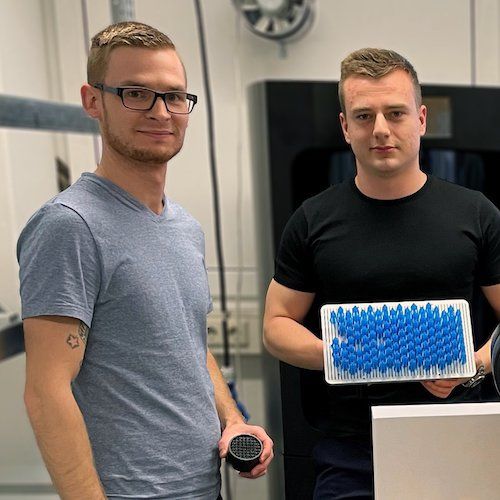 ProductionToGo team members display photopolymer parts from Nexa3D printers.