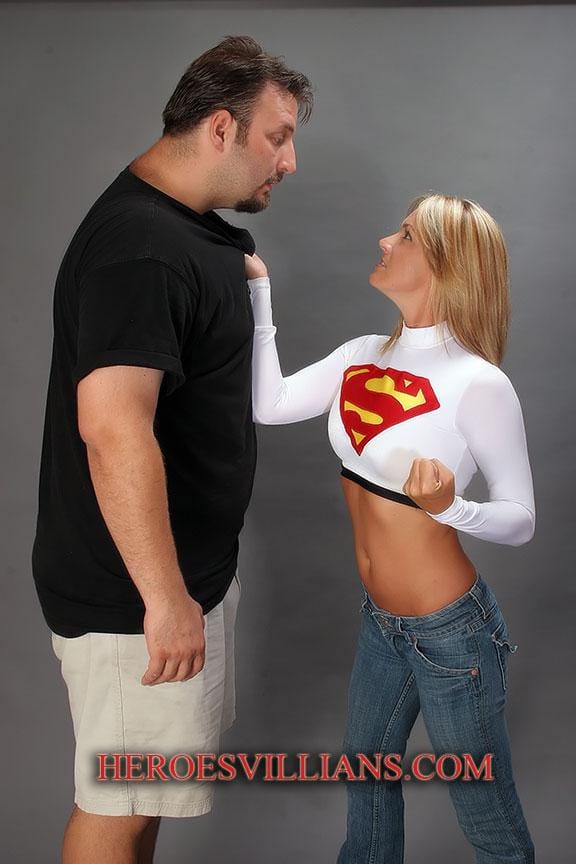 Supergirl in white costume beating up a bad guy