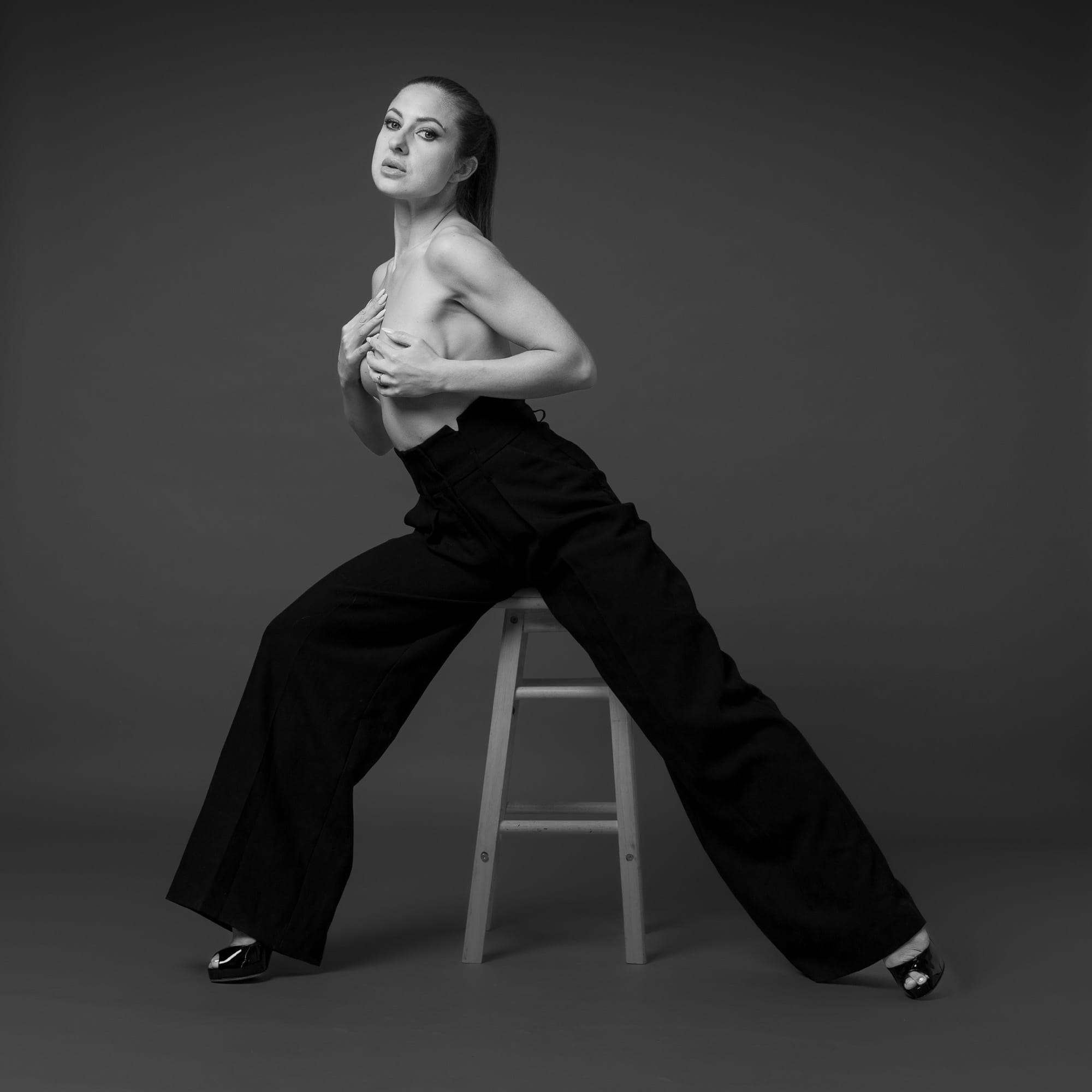 High-waisted trousers fashion portrait in black and white studio light