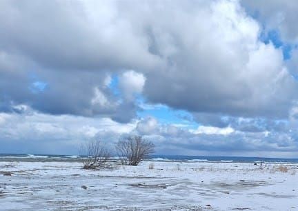 The Lake Michigan shoreline, lots of snow and ice, some fluffy grey clouds