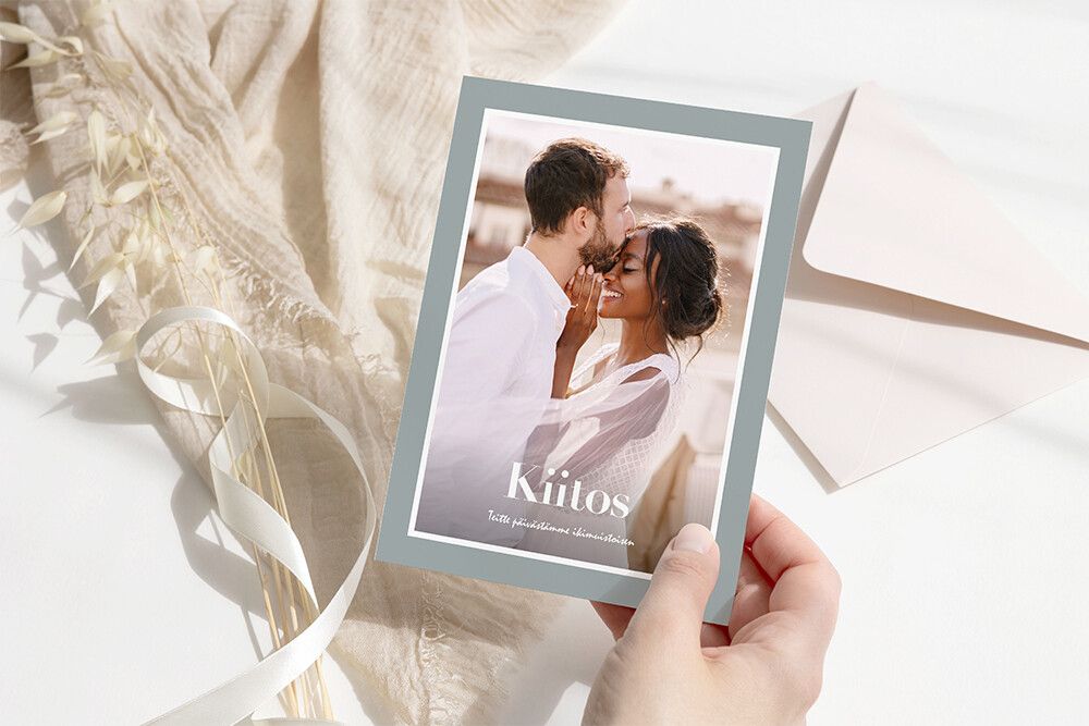 Kutsukortit ja kiitoskortit Venuu blogissa. Kiitoskortti, jossa valokuva pariskunnasta. Taustalla kirjekuori ja vaaleaa kangasta. Kuvakortit Ifolorin valikoimasta.