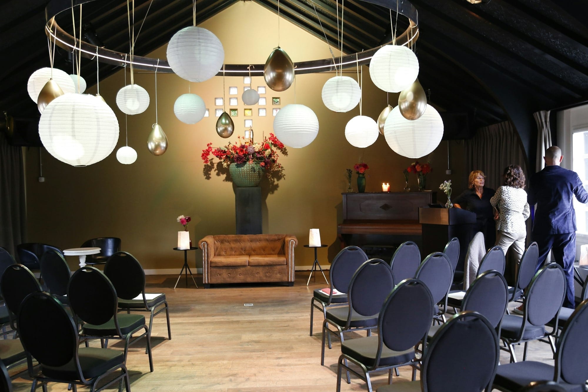 An event room with chairs, a decorative chandelier, and flowers