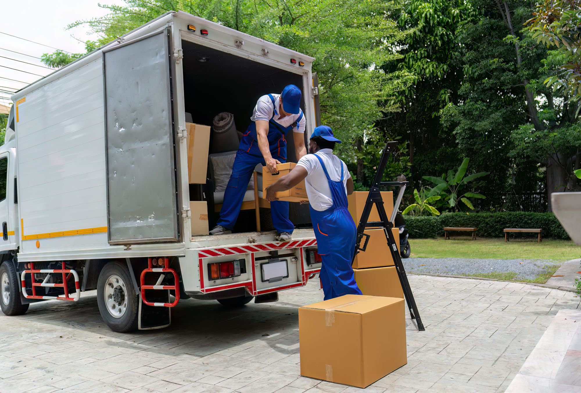 Two professional movers load a box truck with boxes while on a job.