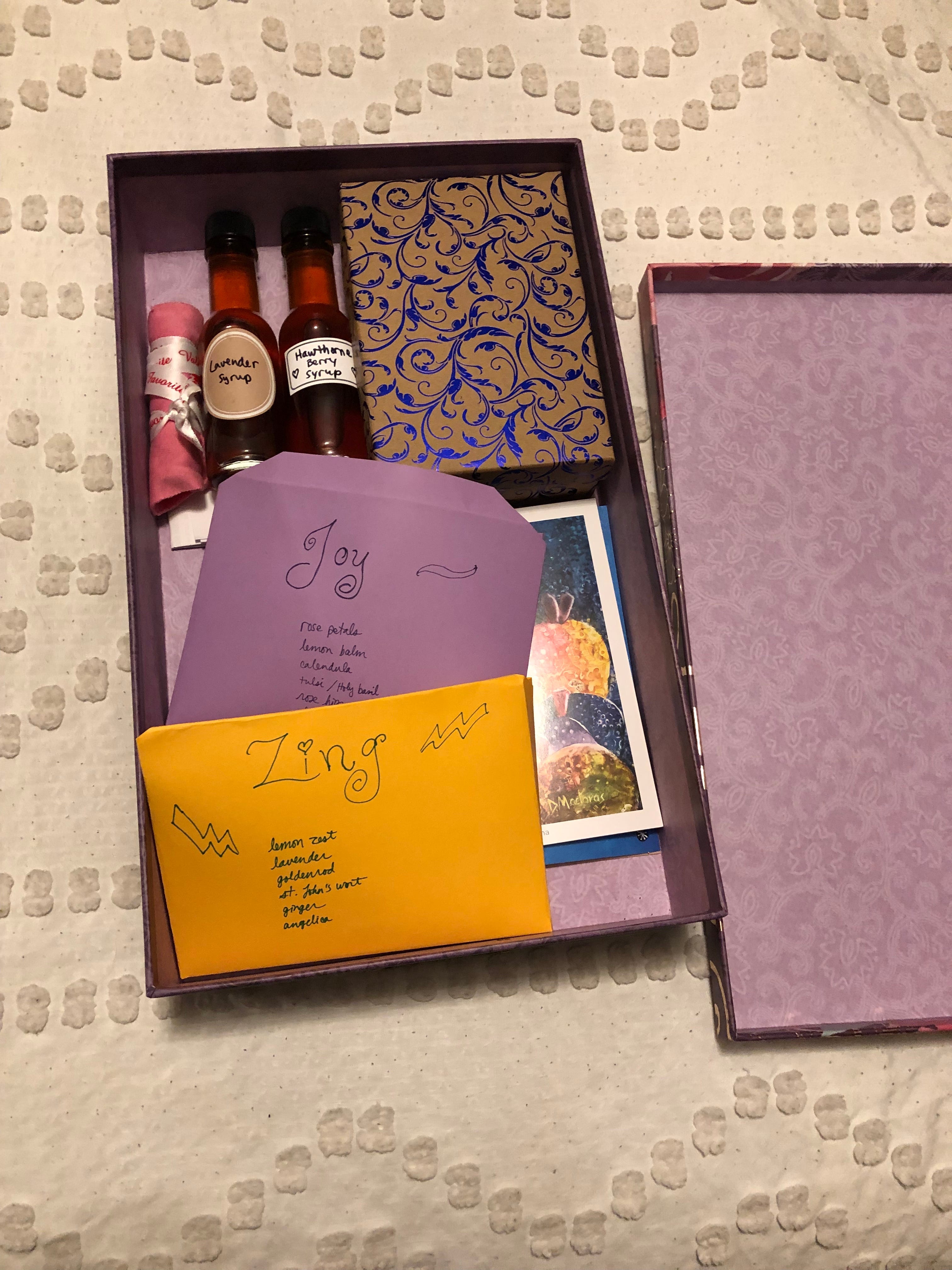 Box containing syrups, truffles, teas, cards, and other items