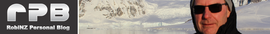 Cropped selfie, hooded jacket over head, Antarctic snow and mountains in the background
