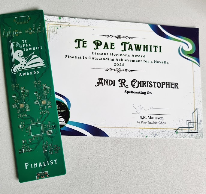 A green bookmark like a circuit board with the Te Pae Tawhiti Awards logo, next to a certificate recognising Spellcasting On as a finalist in the novella category