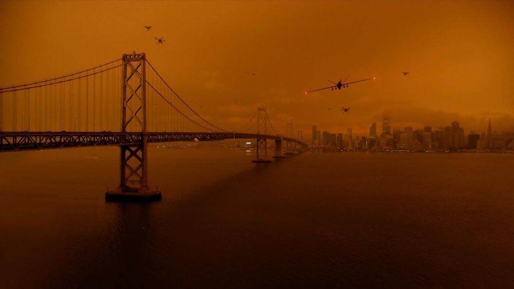 San Francisco and the Golden Gate bridge are shrouded in a deep red while drones fly overhead.