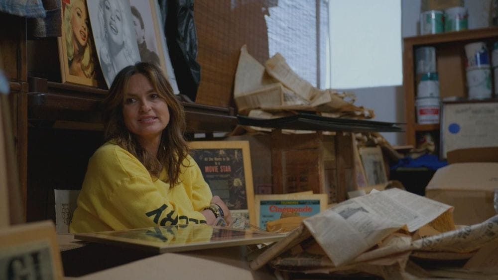 Mariska Hargitay sits in a garage surrounded my old Hollywood memorabilia of her mother including headshots and movie posters.