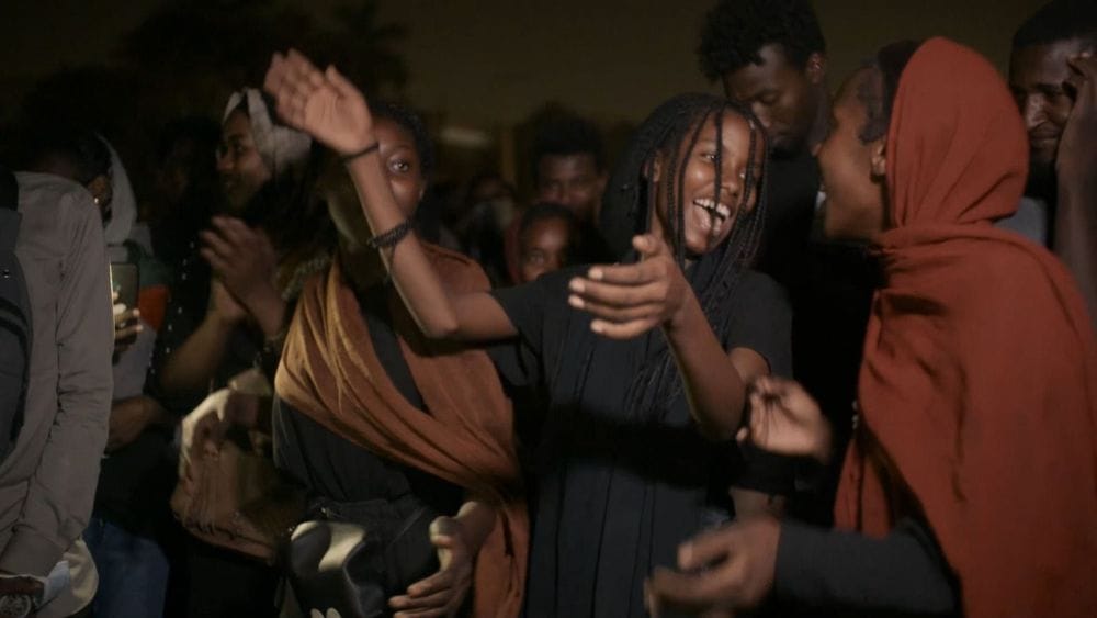 Sudanese women celebrate and dance in the street.