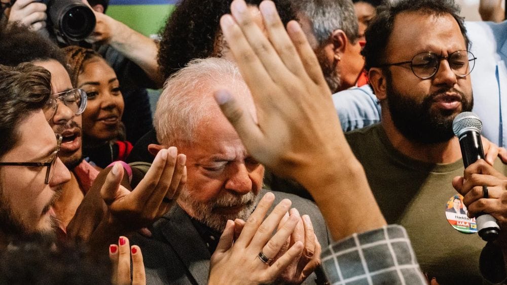 Lula surrounded by people with cameras and microphones.