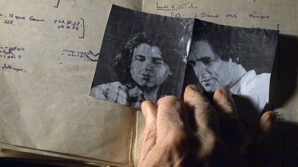 An old black or white photograph of two men from inside an old diary or sketch book.