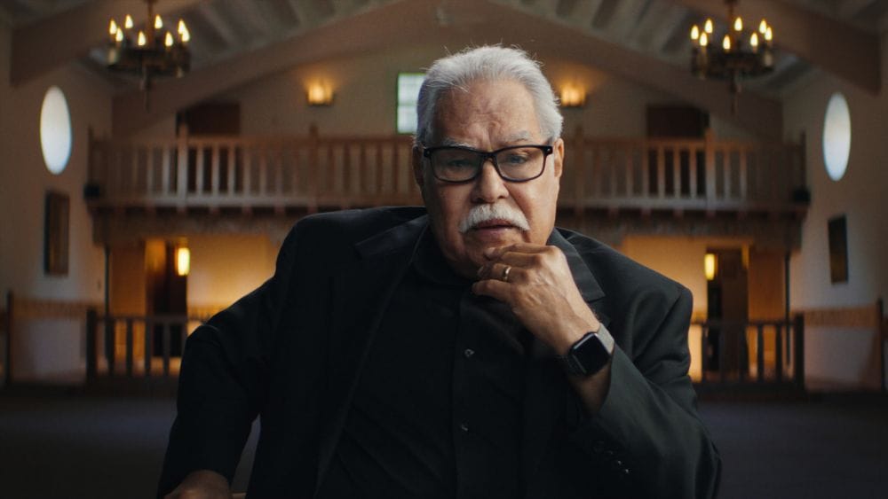Luis Valdez sitting for an interview in a suit with grey hair and moustache.