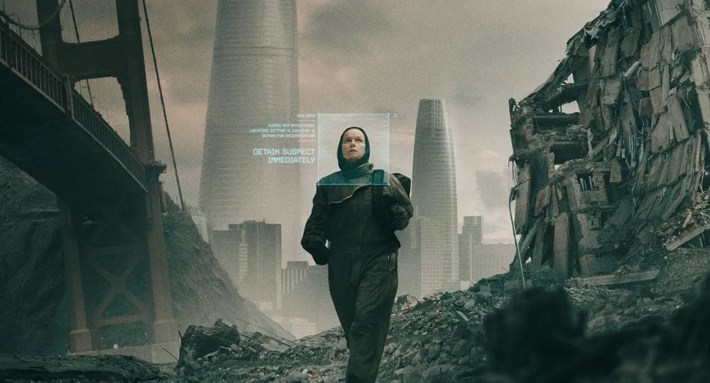 A woman in protective clothing walks through the futuristic ruins of San Francisco.