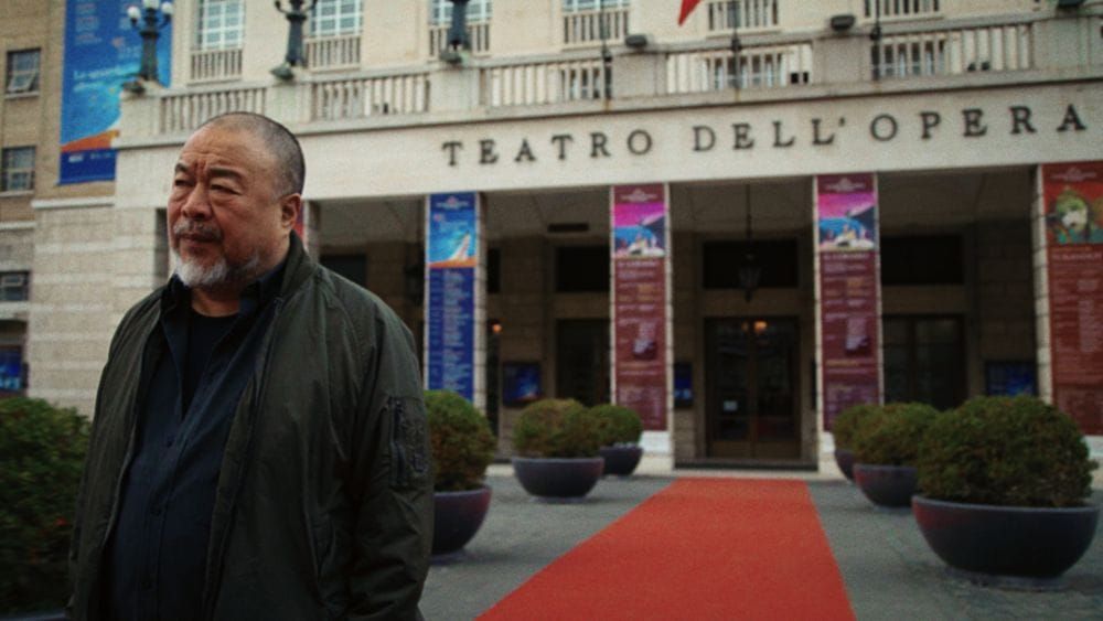 Ai Weiwei (pronounced eye way way) stands in a dark jacket outside the Teatro Dell'Opera.