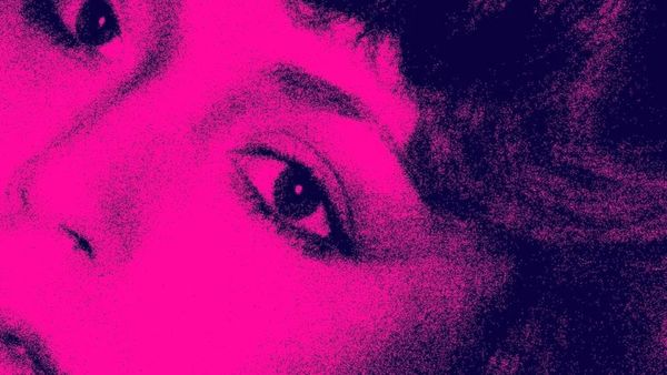 Stylised pink photograph of a transgender woman looking at the camera.