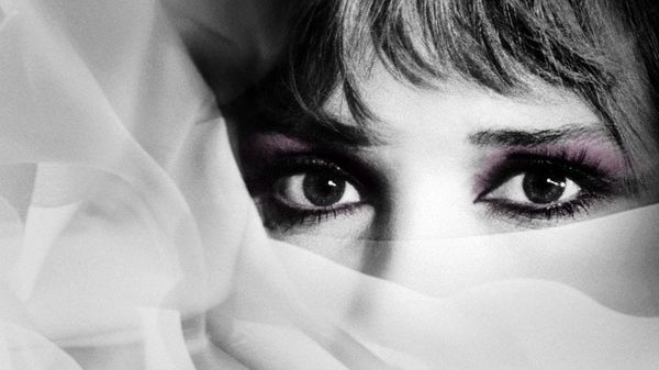 Black and white close-up of a woman's eyes with the rest of her face covered in sheer fabric.