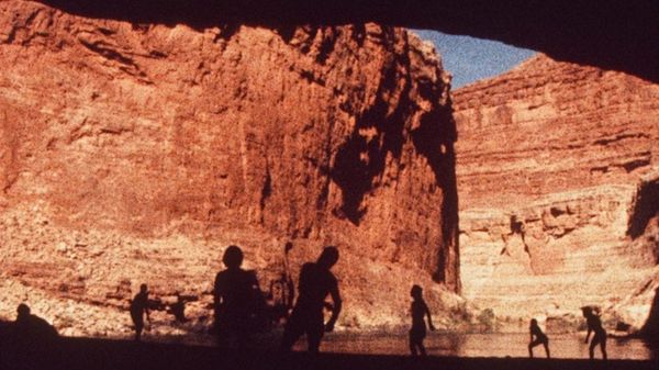 16mm footage of naked naturists in silhouette among the high red rock walls of the grand canyon.