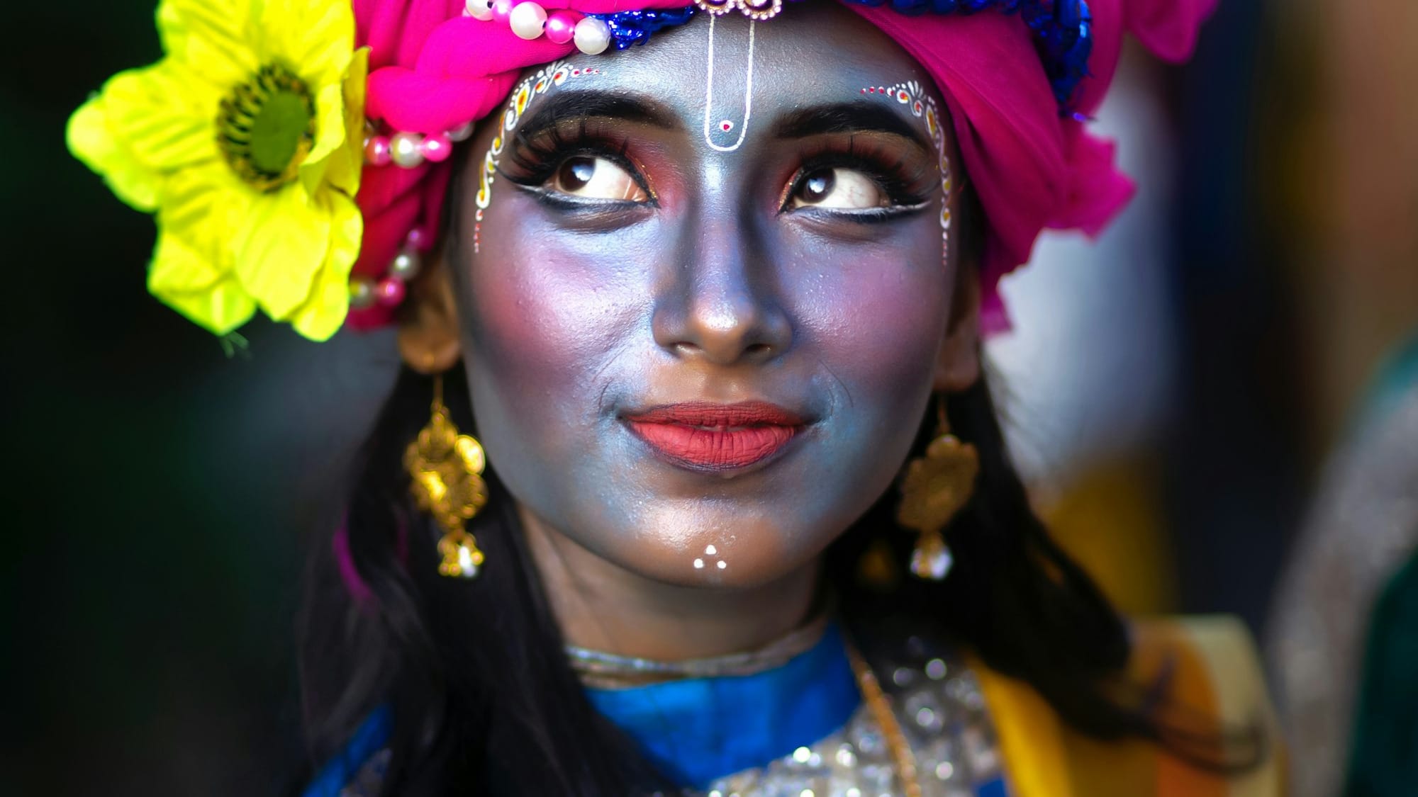 A woman with a painted face and a flower in her hair