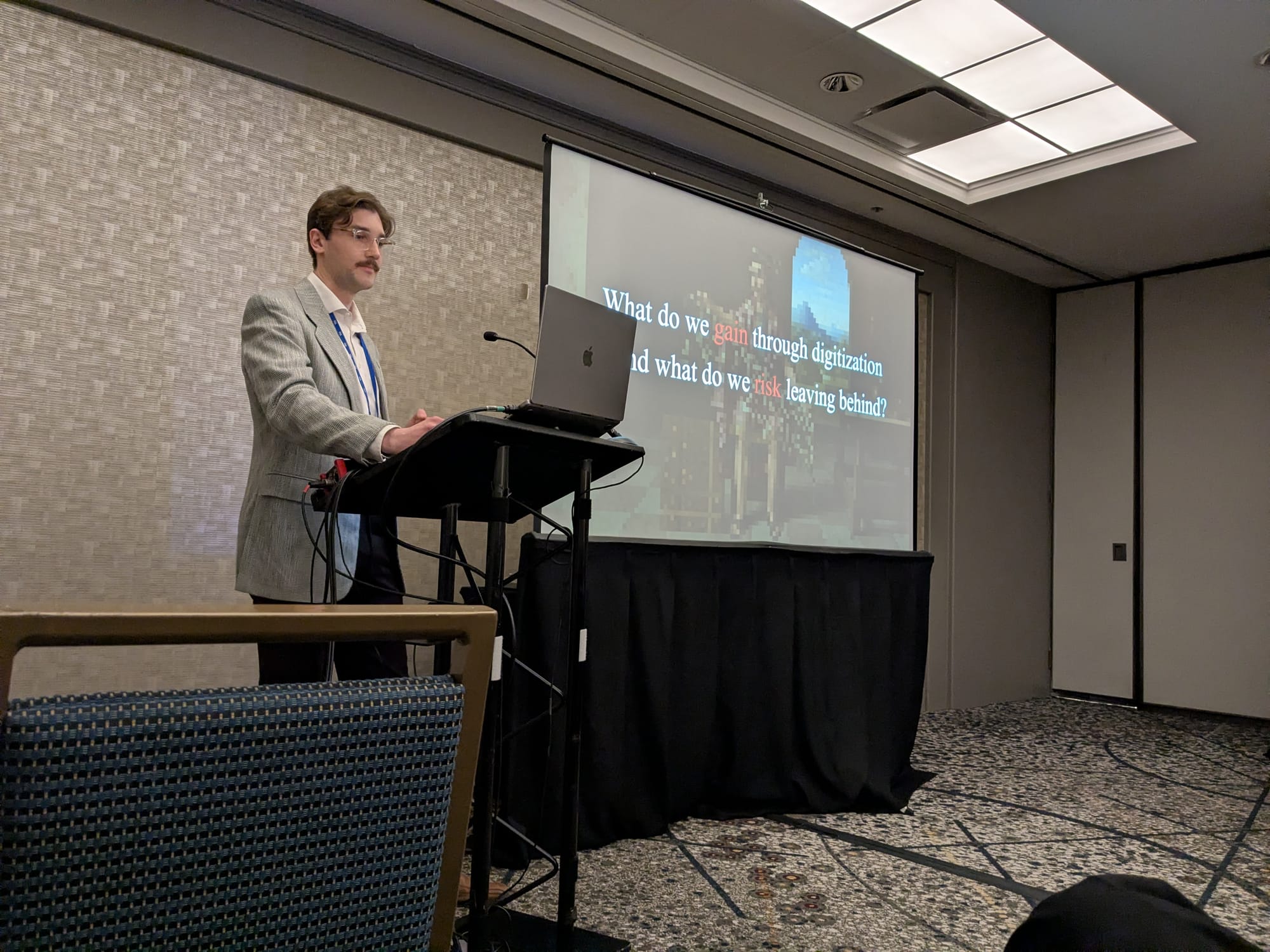 Photo of FitzPatrick presenting at SAA, with slideshow in background