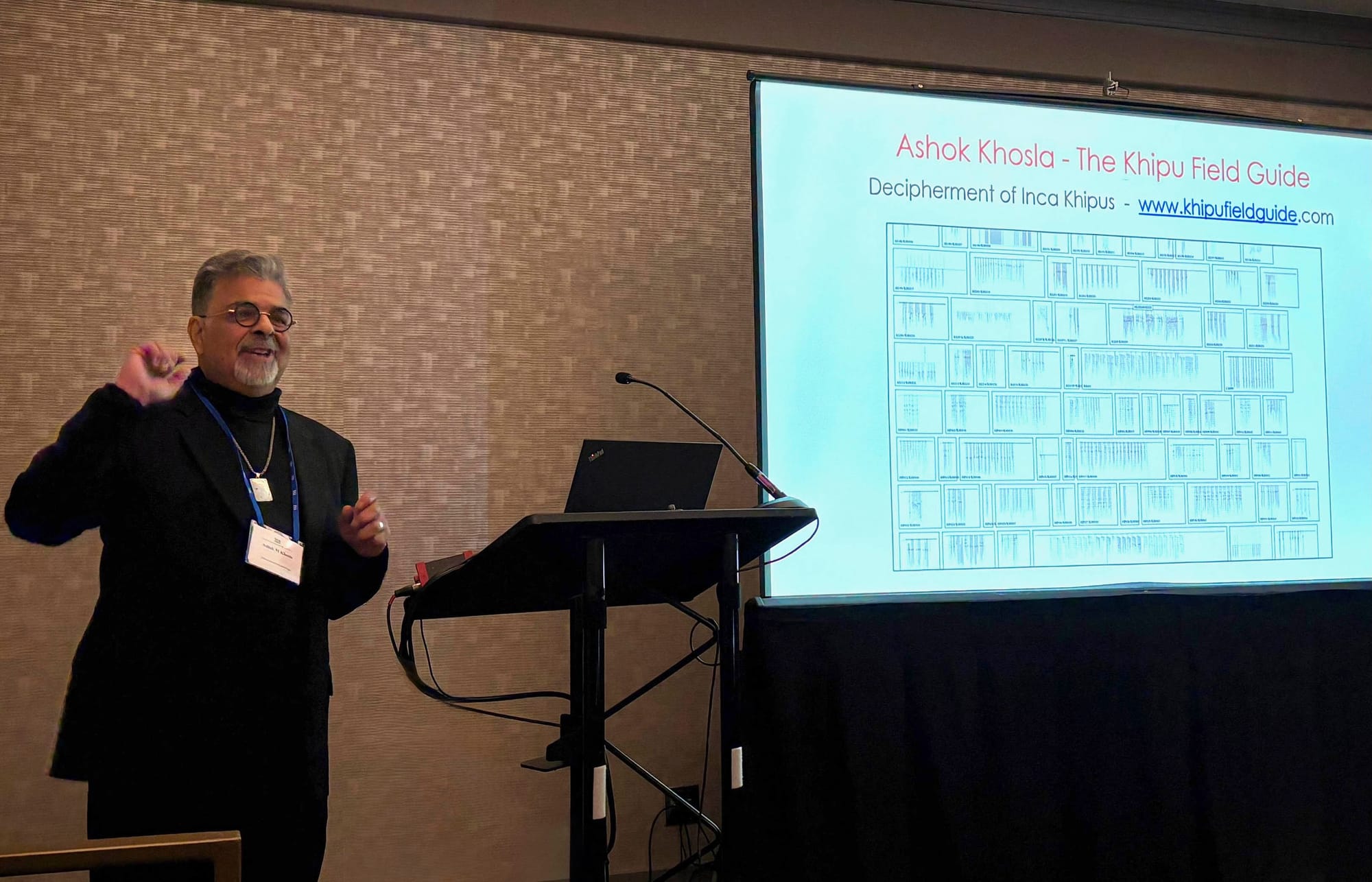 Photo of Khosla presenting at SAA, with slideshow in background