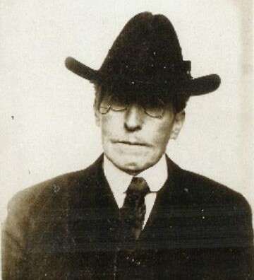 Old photograph of a man with glasses, a large hat, and a tie.