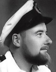 A black and white picture of Michael Dillon, a bearded man wearing a sailor's uniform.