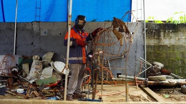 A person wearing a mask and standing next to a metal structure
AI-generated content may be incorrect.