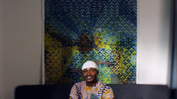 A person sitting in front of a painting
AI-generated content may be incorrect.