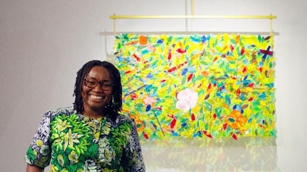 A person smiling in front of a colorful art piece
AI-generated content may be incorrect.