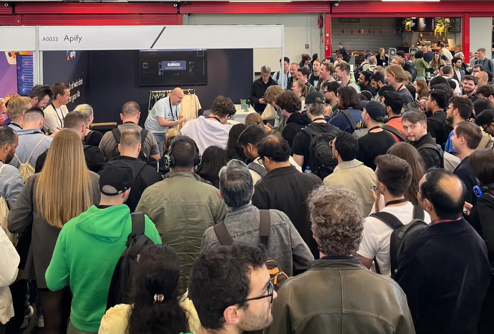 Apify conference booth with a crowd of people visiting