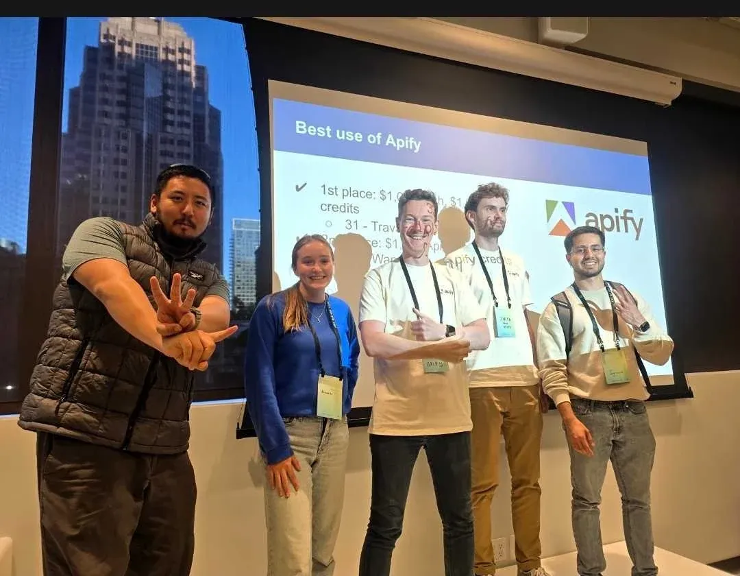Hackathon winners on stage in front of a slide announcing the Best use of Apify prize