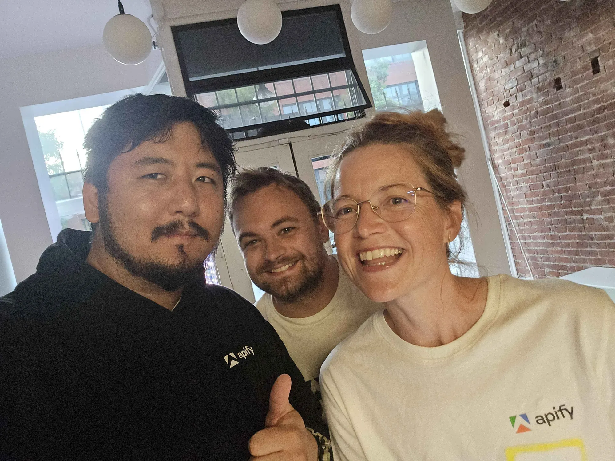 Petros Hong with two Apify colleagues wearing Apify t-shirts at the San Francisco office