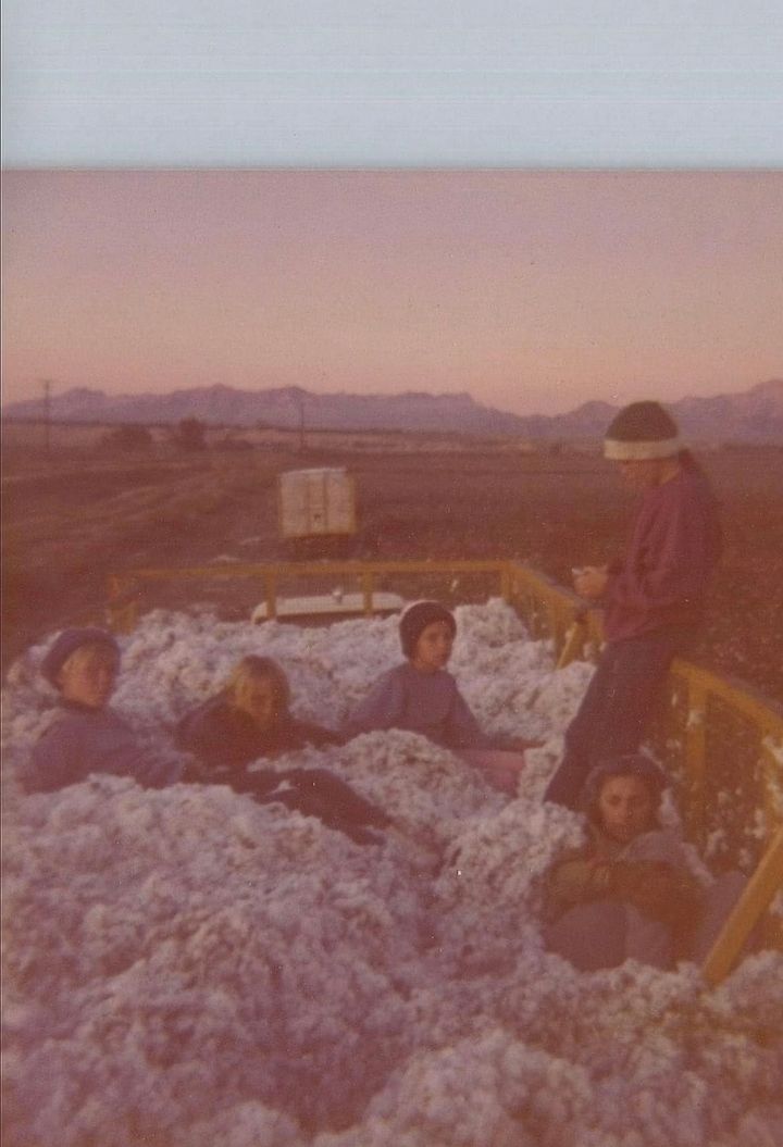 MEMAW as a girl standing with her aunt and cousins while tromping cotton in a farm trailer.