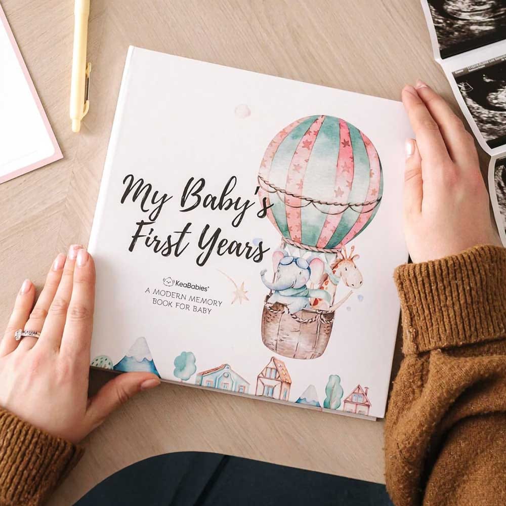 Baby memory book journal with milestone pages, keepsake envelope, and photo slots — thoughtful gift for new moms