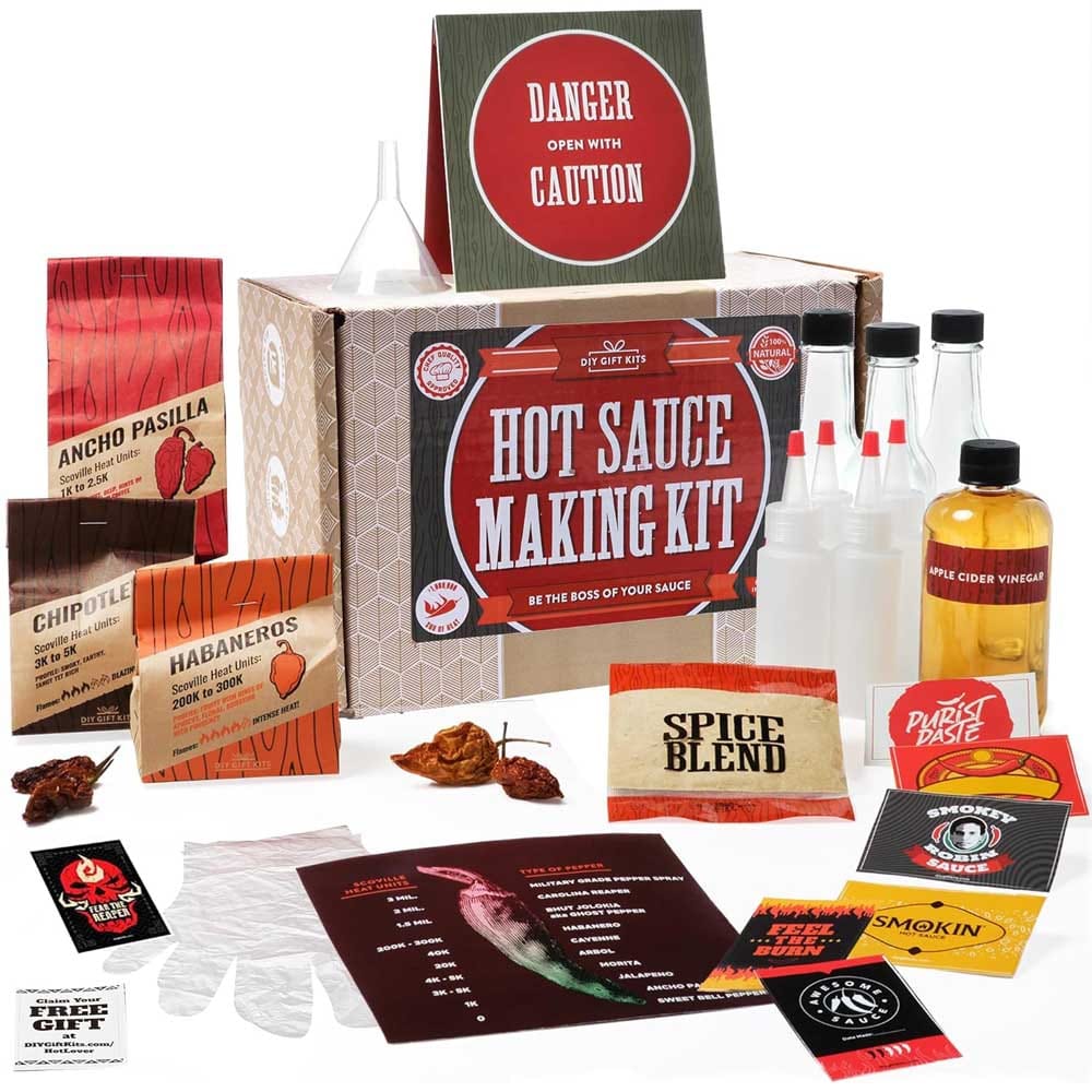 Hot sauce making kit with bottles, spice blend, vinegar, peppers, gloves, funnel, and instructions — DIY gift for spicy food lovers