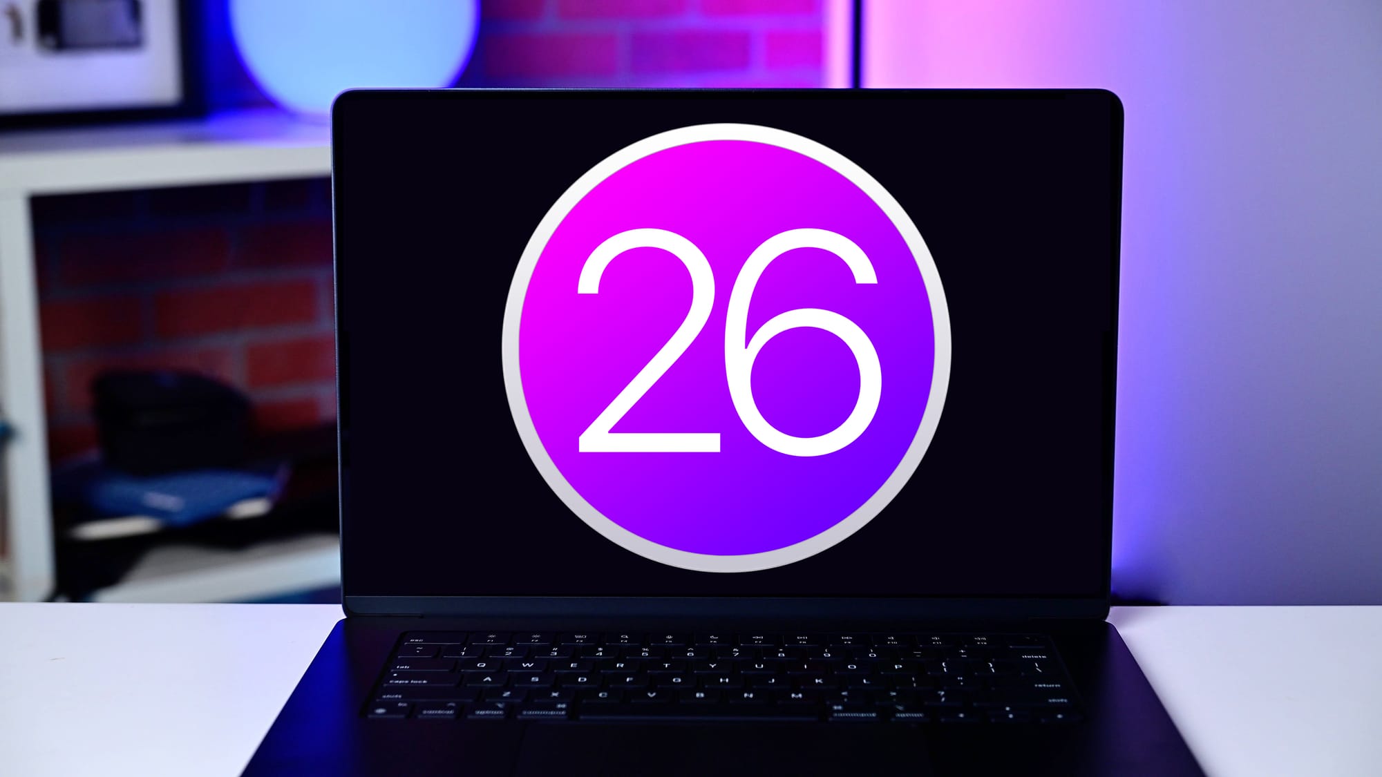 A MacBook on a desk with an image of a circle and the number '26' inside