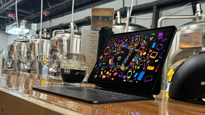 13-inch iPad Pro in the Magic Keyboard with a colorful background. It sits on a bar top at a brewery.