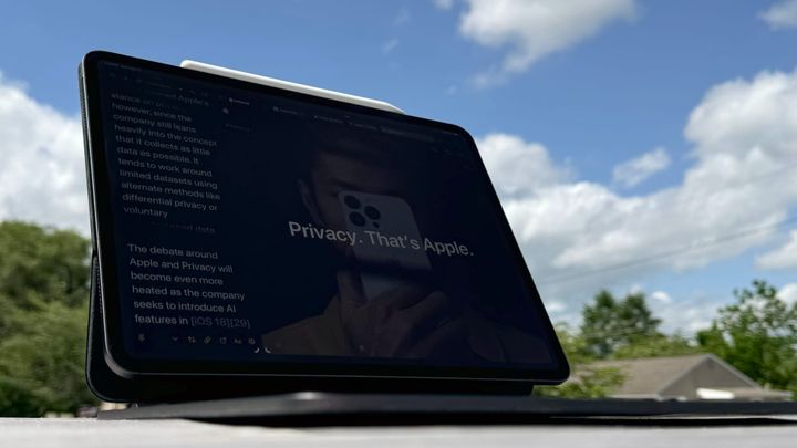 iPad on a table outdoors showing a "Privacy. That's Apple." ad.