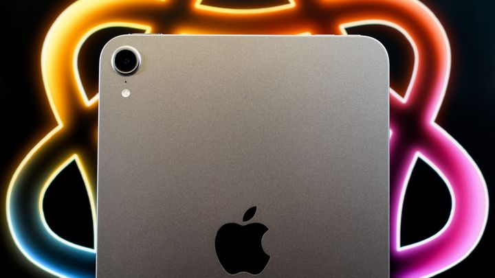 The iPad mini in front of the Apple Intelligence rainbow braid logo
