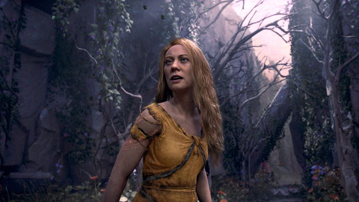A screenshot of "God of War: Laufey" showing Faye in a tattered dress surrounded by fantasy woodlands.