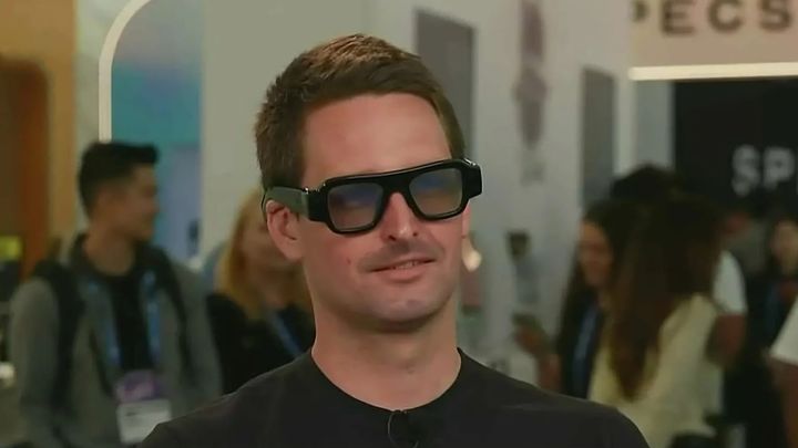 Snap CEO Evan Spiegel wearing the giant Snap Specs on CNBC, his ear curling under the weight