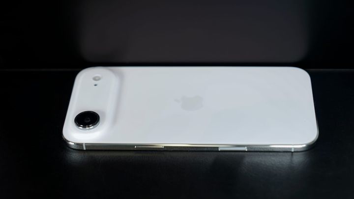 An iPhone Air set by a reflective surface showing a blurry version side-by-side