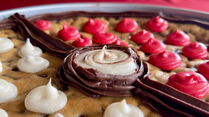 A Pokemon-themed cookie cake shot up close with a chocolate and vanilla swirl in the middle.
