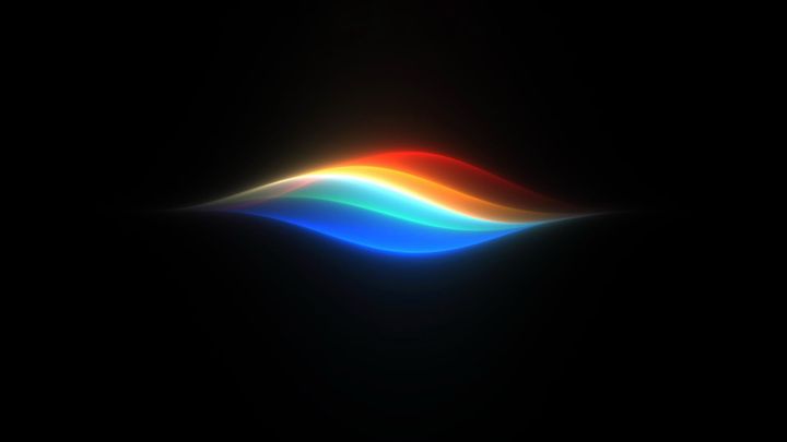 The Siri AI waveform shown with blue, yellow, and red colors on a black background
