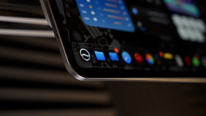 An iPad Pro focused on the dock with an icon for Siri AI