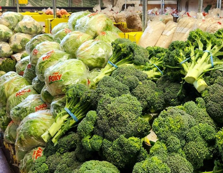 Exhibición de vegetales frescos incluyendo lechuga y brócoli en un supermercado